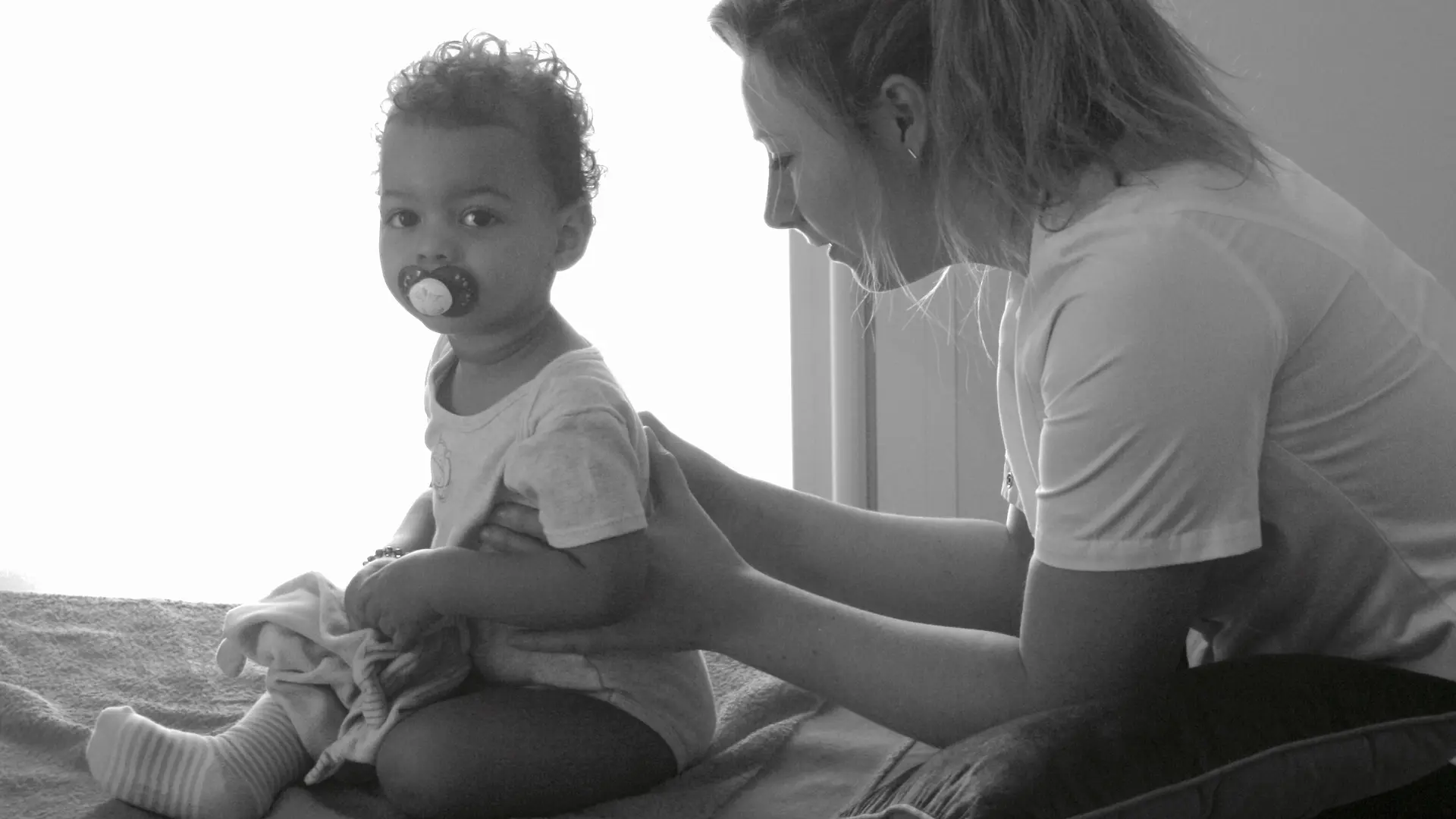 Black and white photo of Morgane working with a child