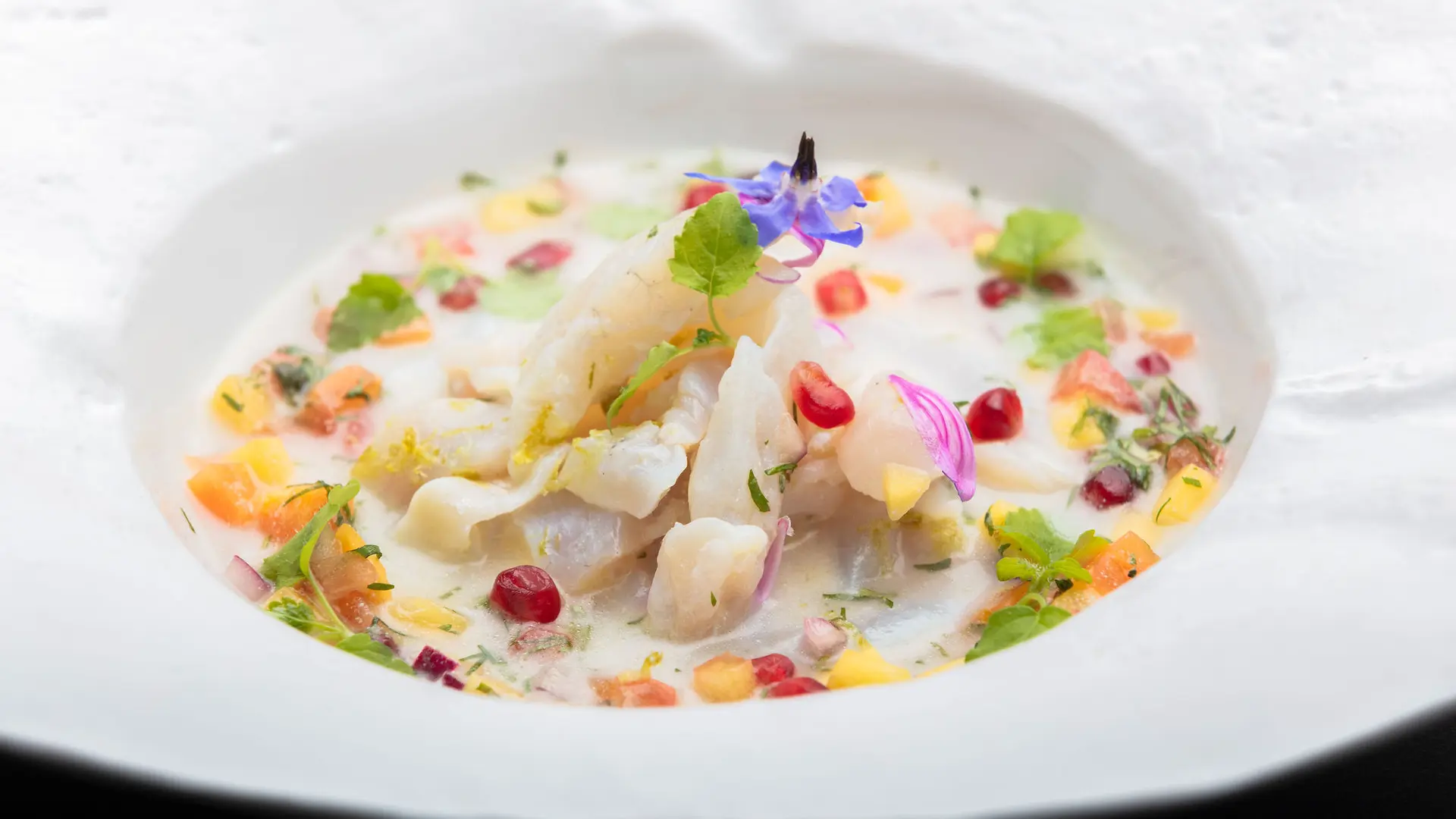 Cette assiette présente une composition culinaire complexe avec une variété d'aliments de différentes textures et couleurs.