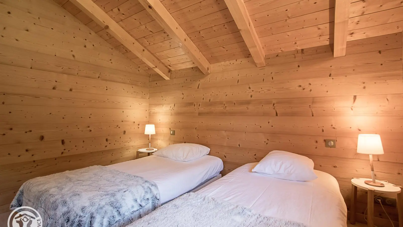 Chambre avec 2 lits 90. Le bois donne la tonalité à l'intérieur à la fois douillet et lumineux.