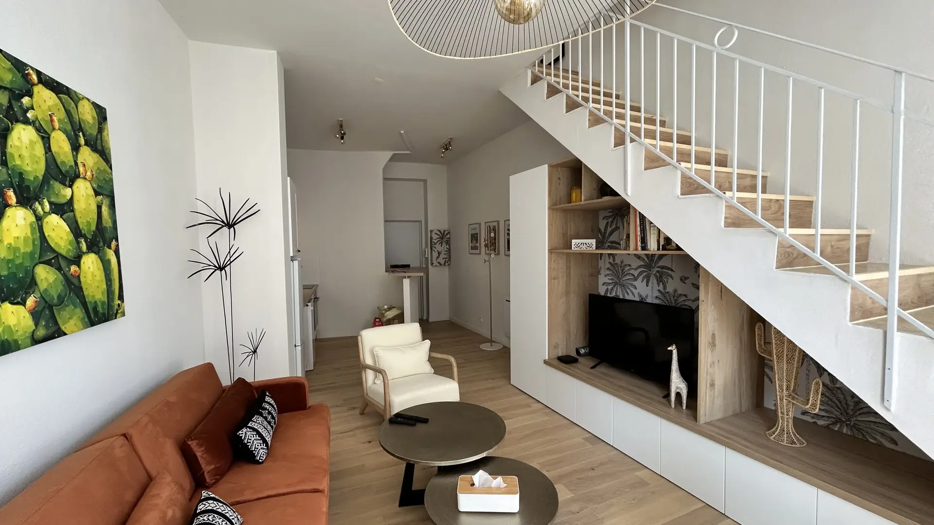 Une perspective complète du séjour, révélant un espace de vie spacieux, chaleureux et parfaitement agencé.