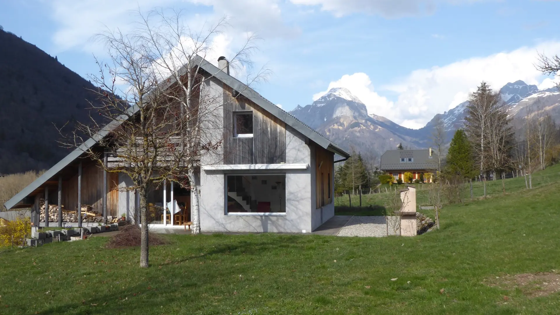 Maison entourée d'un jardin et vue sur les montagnes