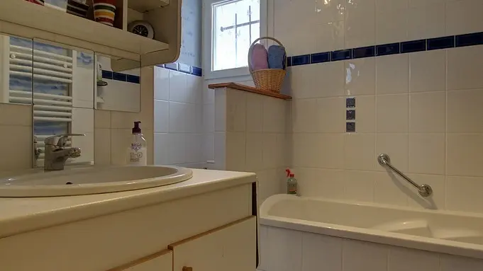 Salle de bain avec douche et baignoire. Ce sanitaire est mitoyen à la chambre. Il faut ressortir de la chambre pour y accéder.