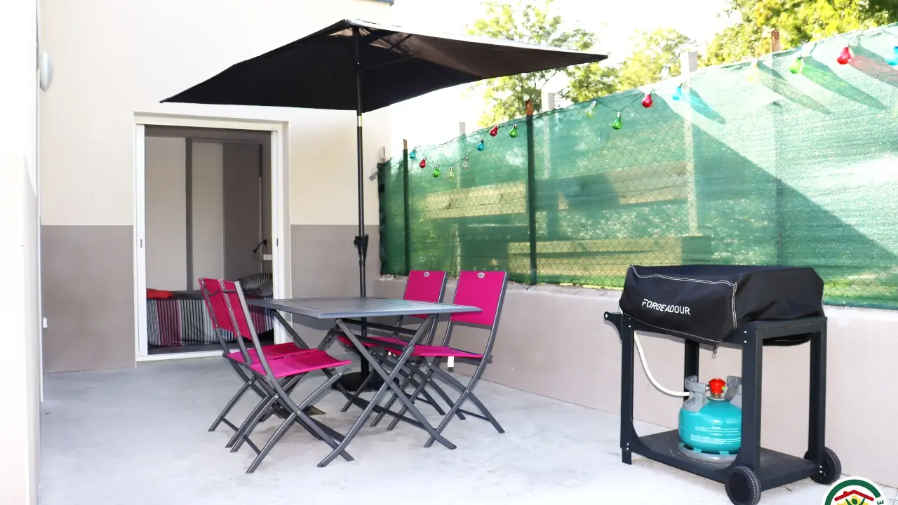 Terrasse avec table à manger et plancha gaz.