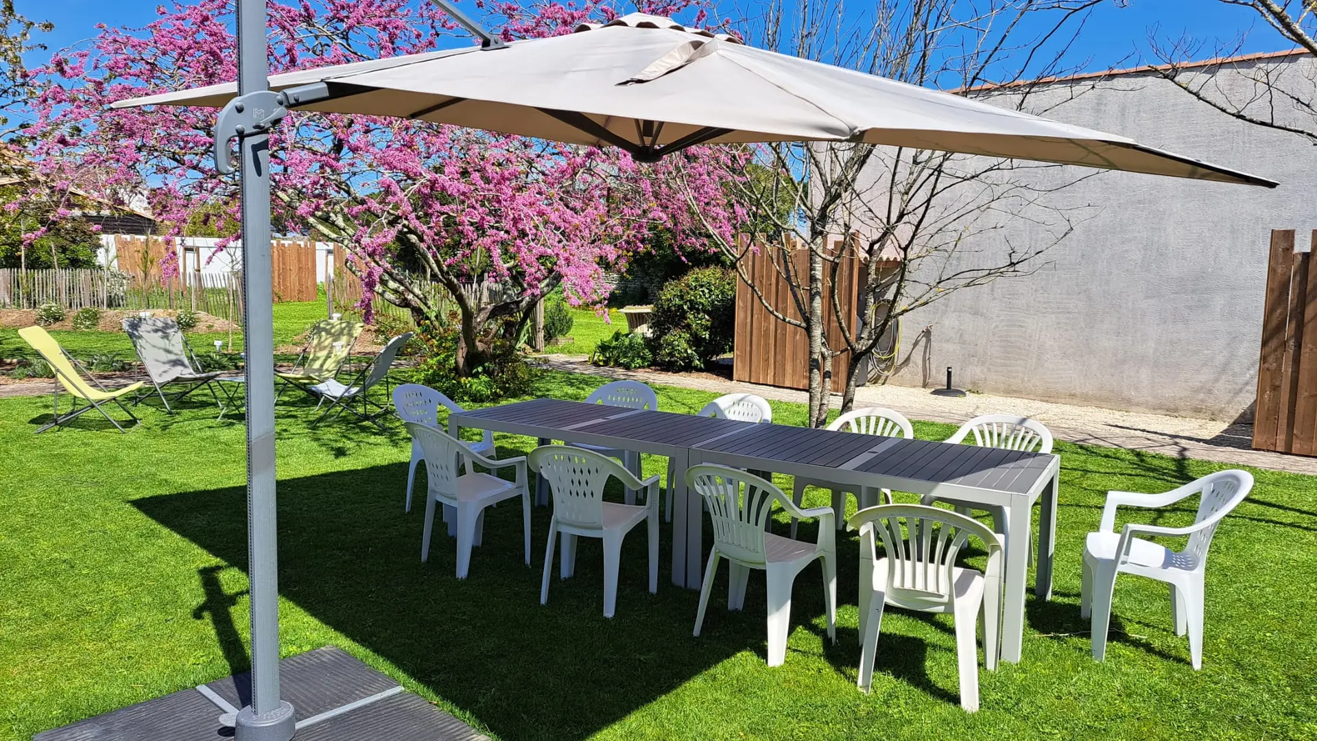 Jardin avec parasol, table et transats