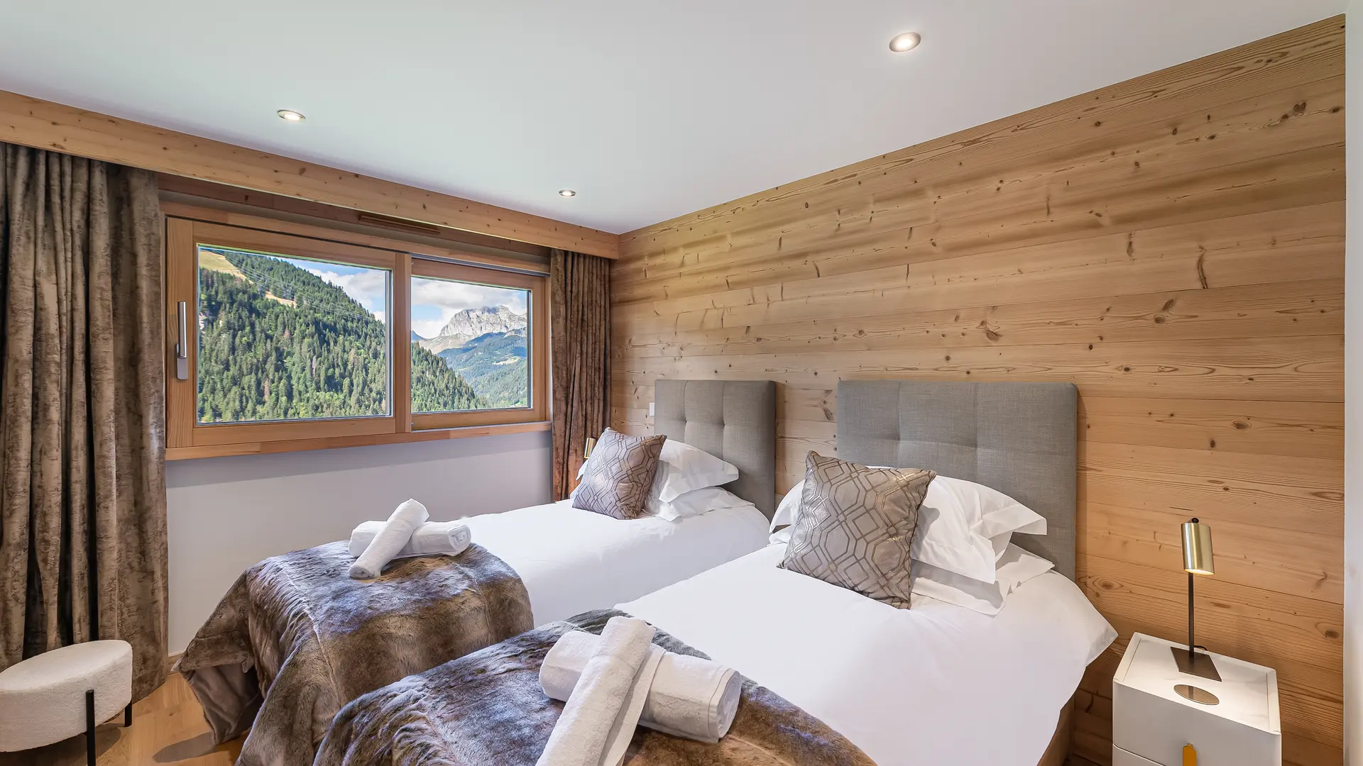 Chambre twin avec grande fenêtre avec vue sur les montanges