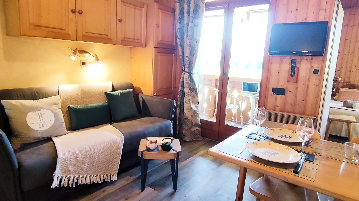 Vue d'ensemble sur le canapé, la table à manger et la chambre avec lit