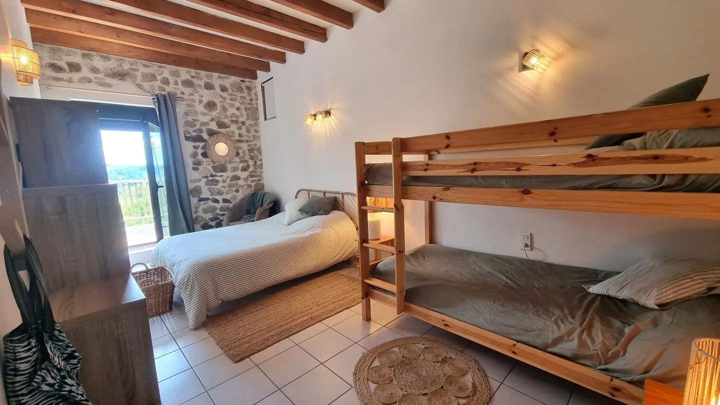 Chambre 3 : un lit 140 et deux lits 90 dont un superposé, avec accès direct sur le balcon.