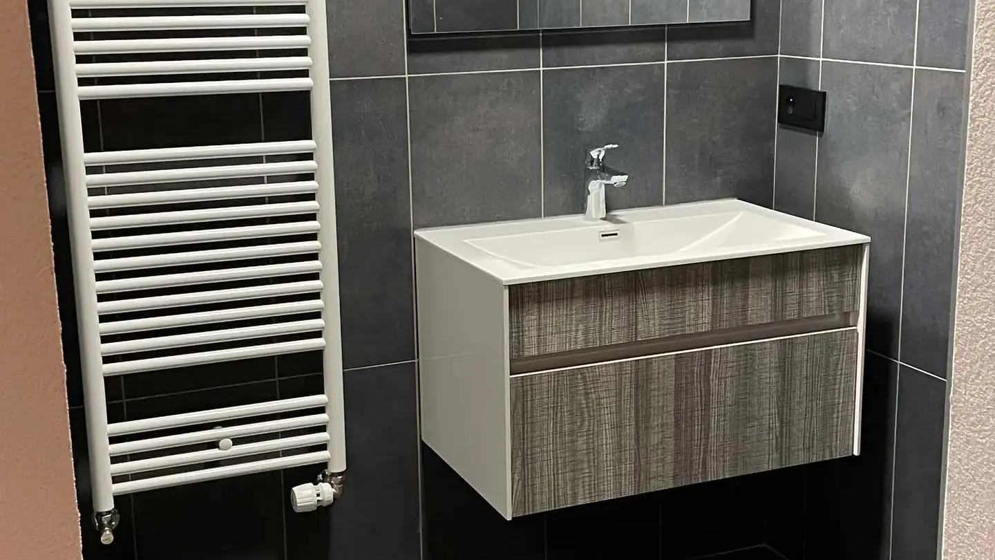 Salle bains modèrne avec meuble vasque, grand miroir et sèche serviettes
