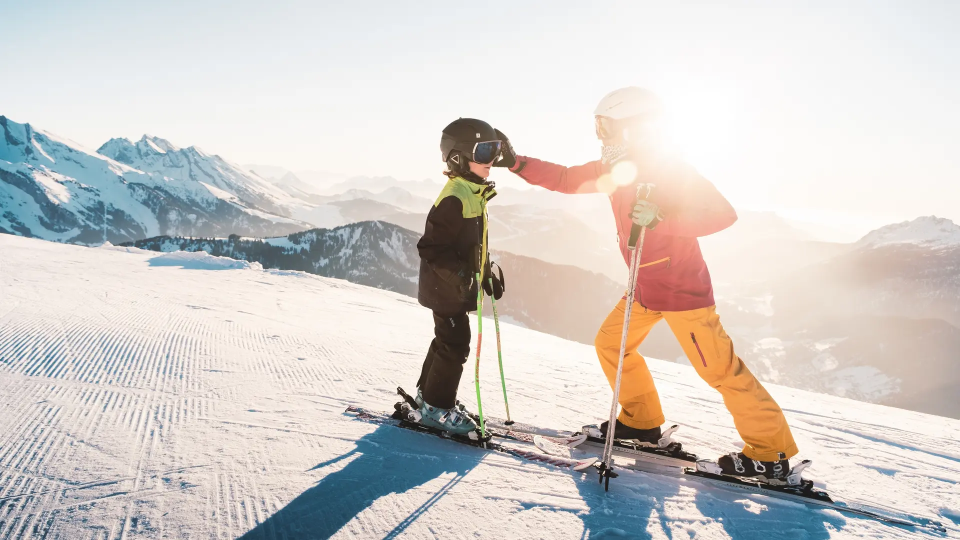 ski alpin au Grand-Bornand au coucher de soleil en famille face à la chaîne des Aravis