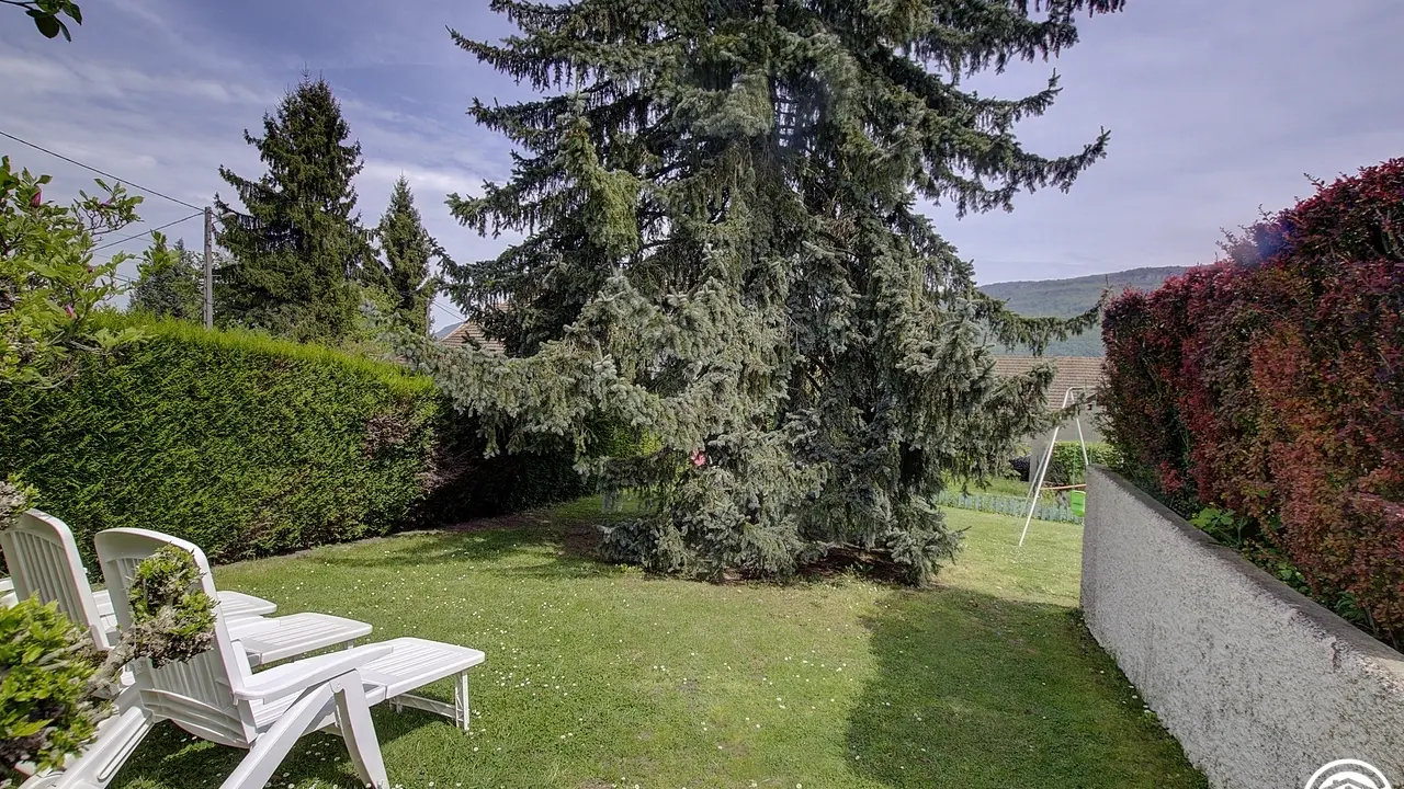 Un jardin agrémenté de jeux de ballons (cage d foot, filet de badminton et panneau de basket)
