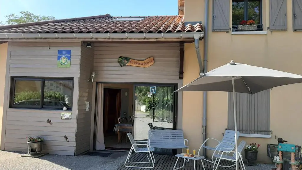Terrasse côté parking et entrée des chambres d'hôtes par la pièce commune.
