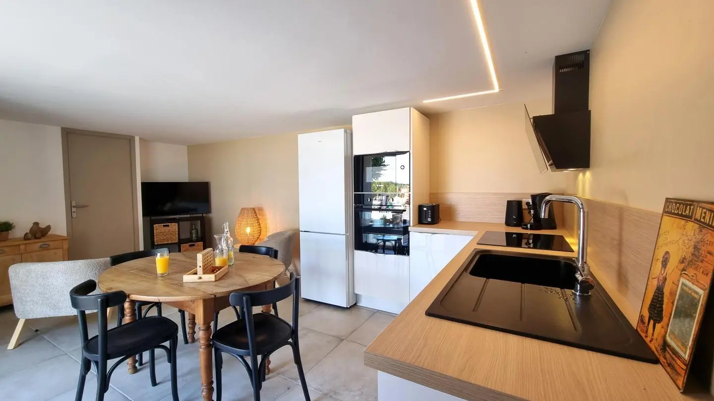 Séjour avec cuisine ouverte sur la salle à manger et le salon.