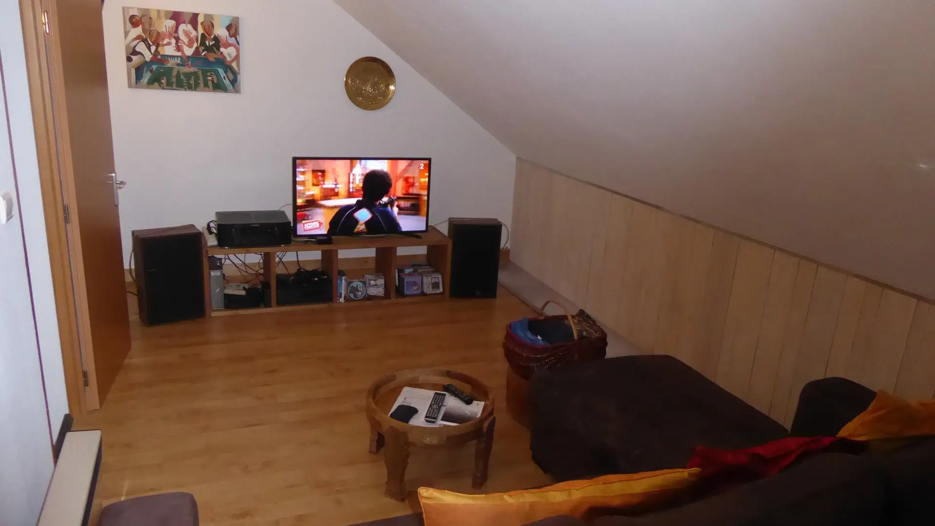 Coin télévision avec un canapé, une télévision et des enceintes