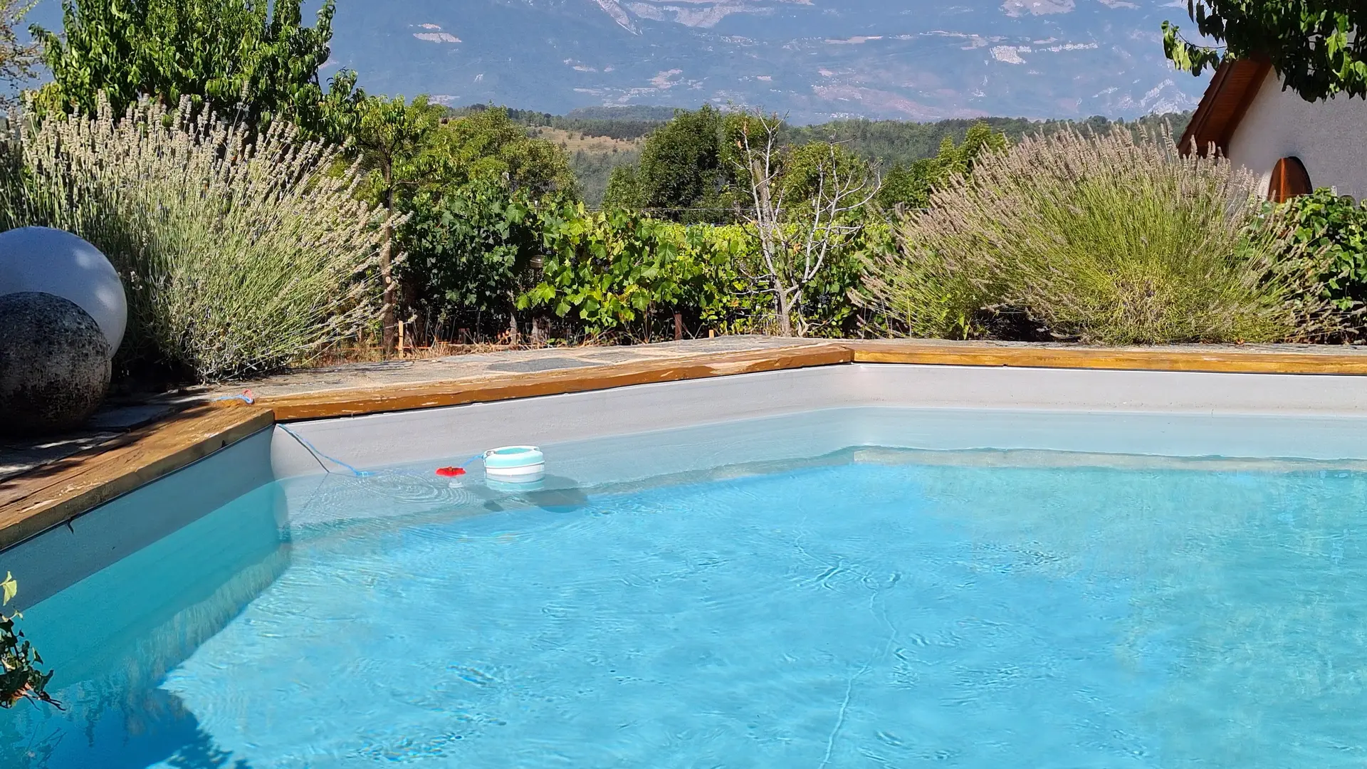 La piscine est située dans un environnement paisible offrant une vue dégagée sur les montagnes environnantes.