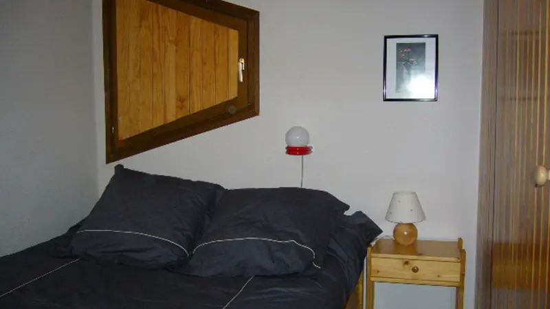 Bedroom chamber with double bed, wood shutter and window