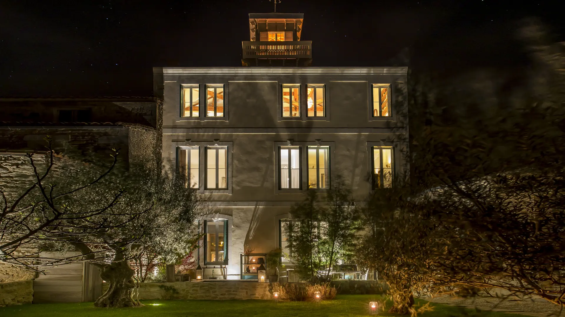 La maison vue du jardin en soirée