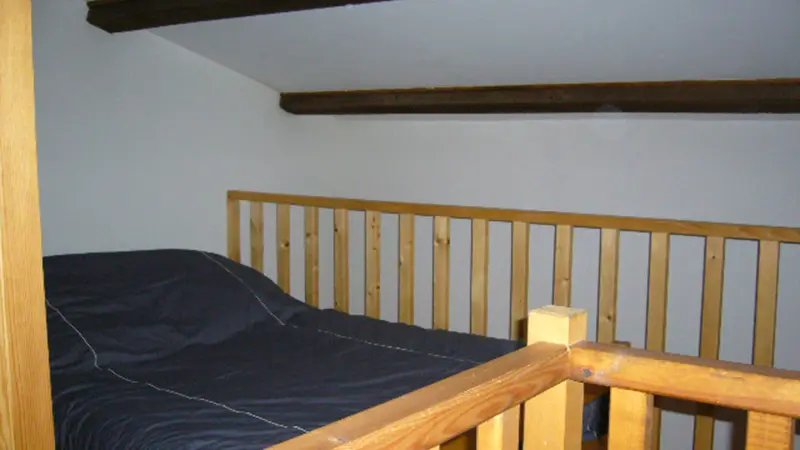 Attic bedroom with double bed and wood railing