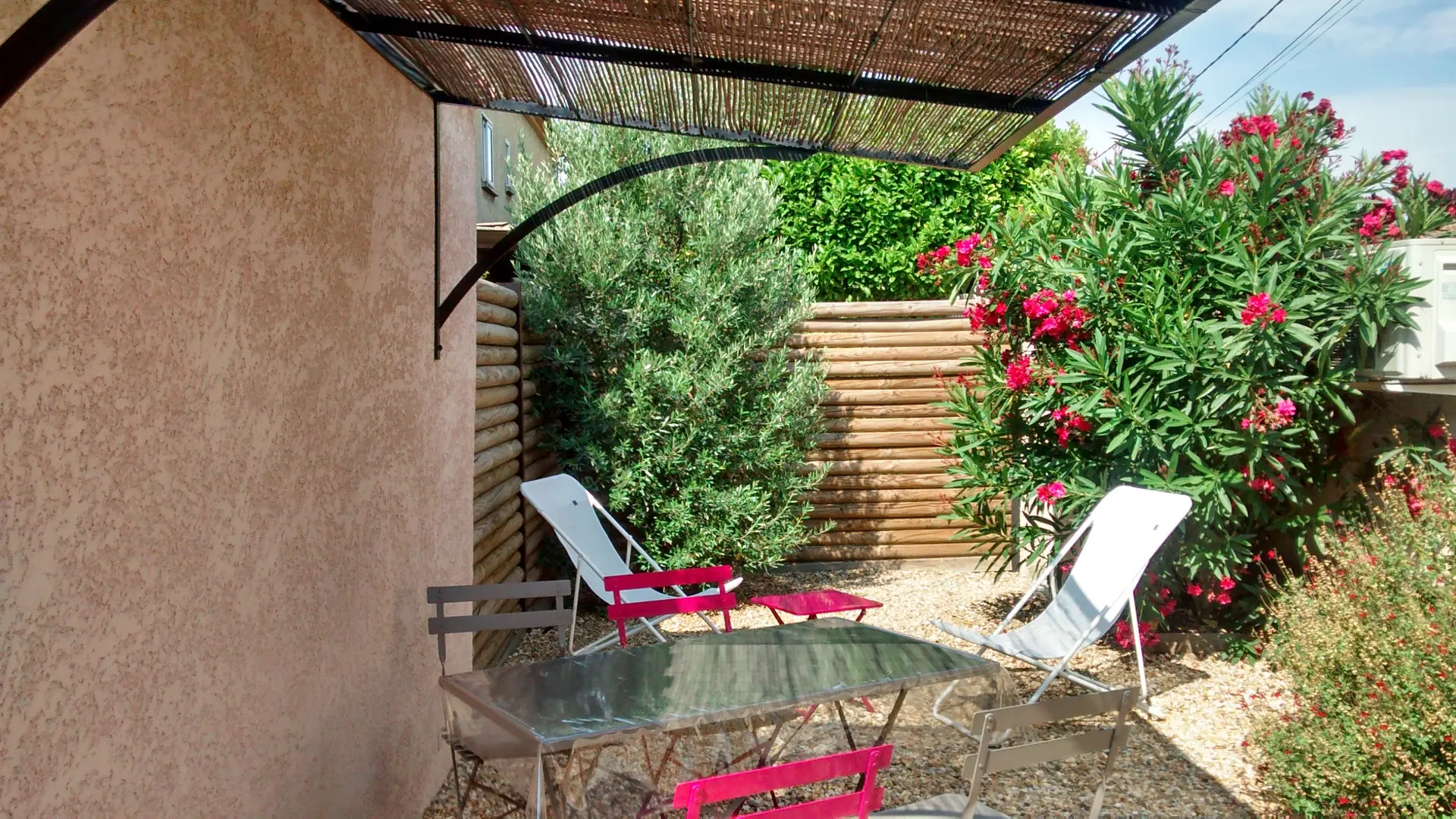 Espace extérieur privatif avec table et chiliennes, idéal pour se détendre au calme.