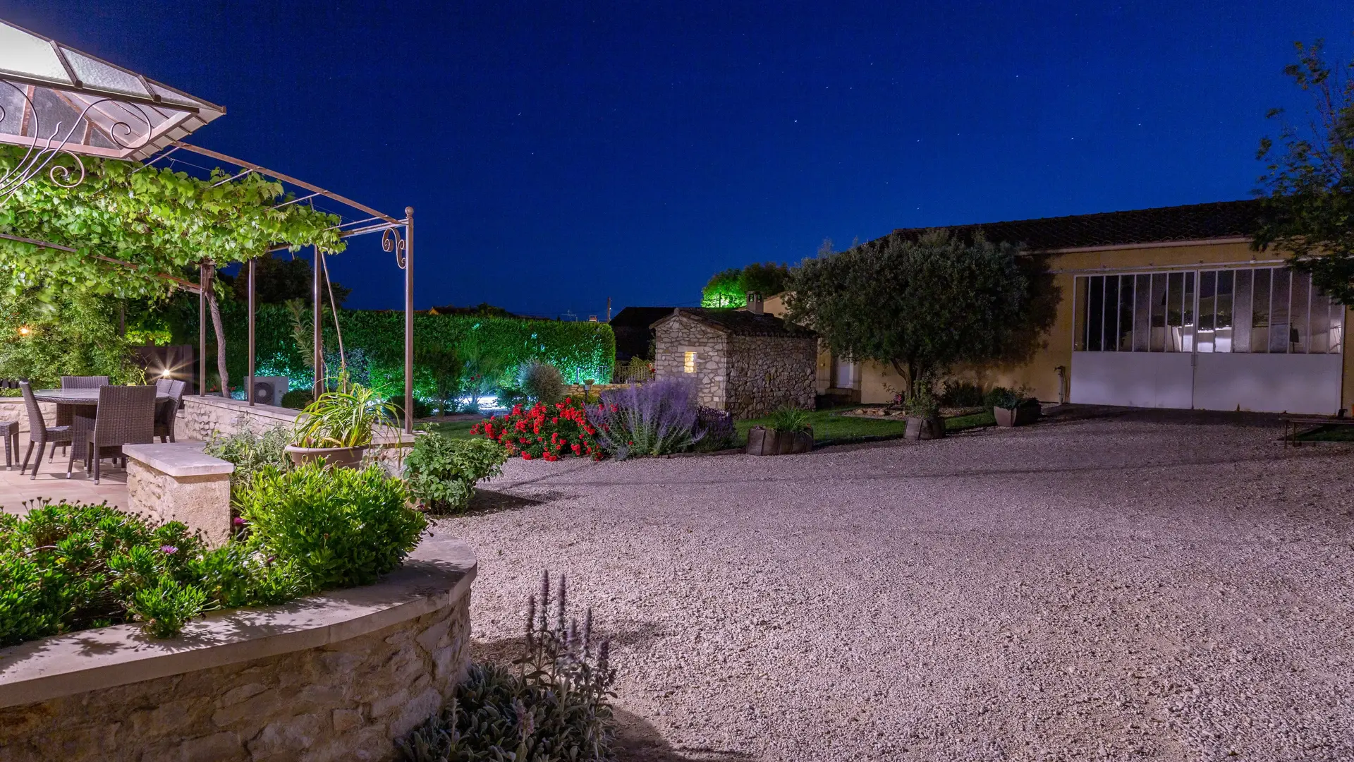 Les extérieurs de la propriété dévoilent un jardin structuré, des allées gravillonnées et des dépendances en pierre, dans un esprit typiquement provençal.