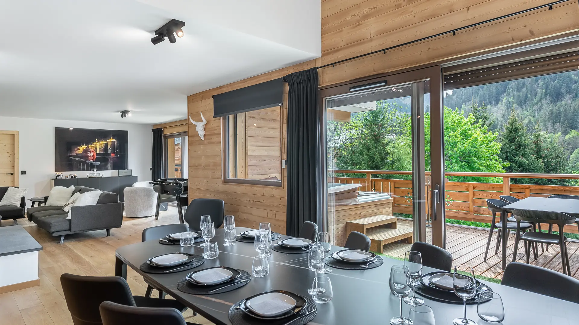 Salle à manger avec sa grande table, accès au balcon par grandes baies vitrées