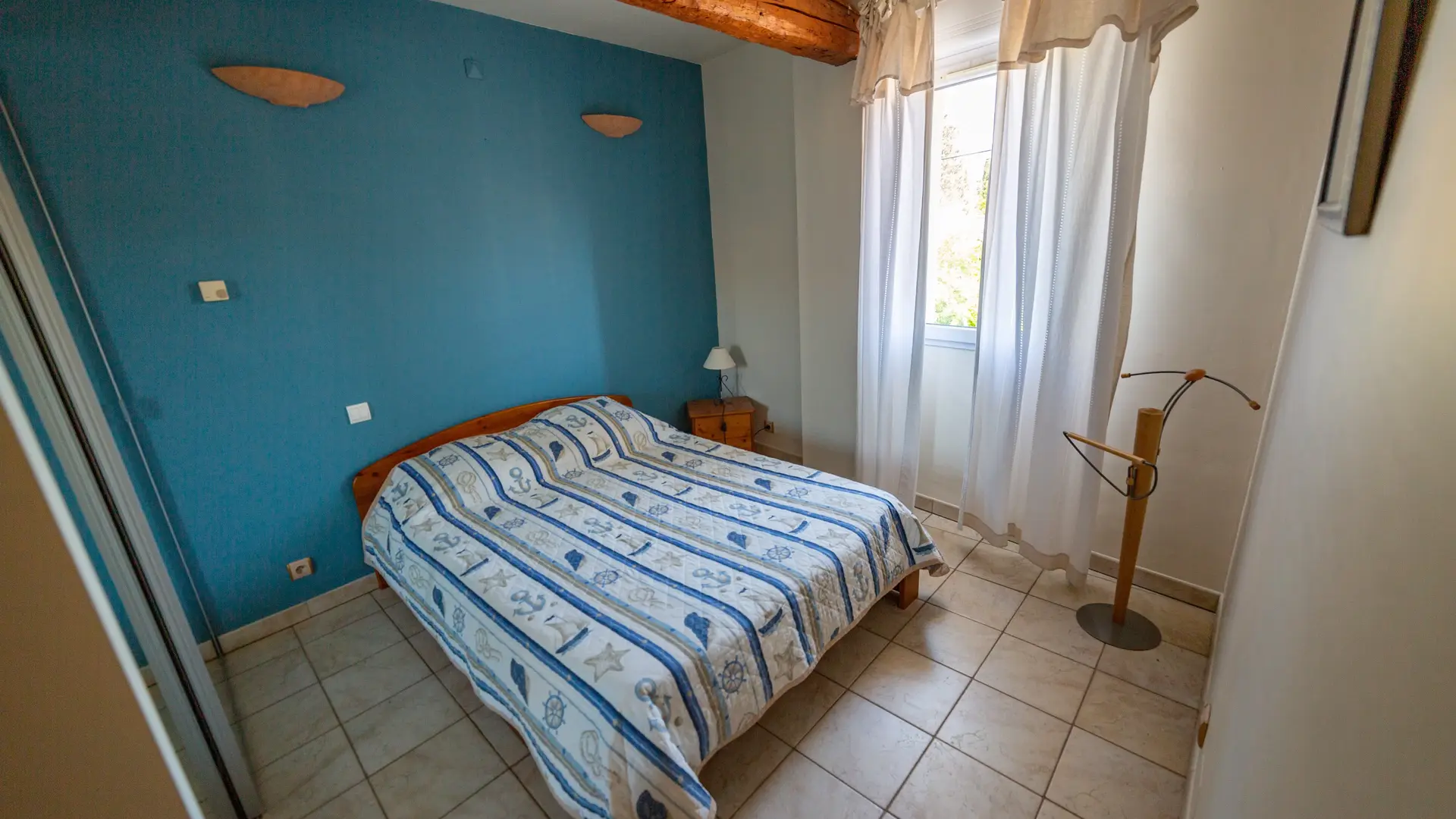 Une chambre double au style simple et apaisant, avec poutres apparentes et lumière naturelle, propice au repos et à la détente.