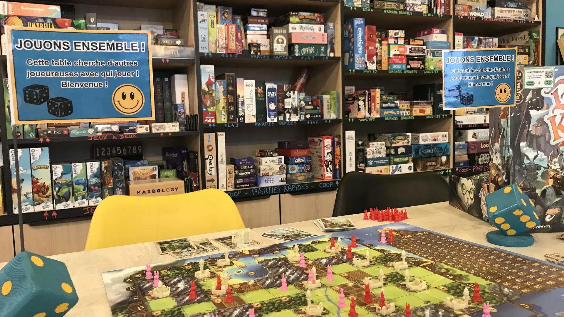 Dés avec drapeaux pour dire que la table accueille des joueureuses