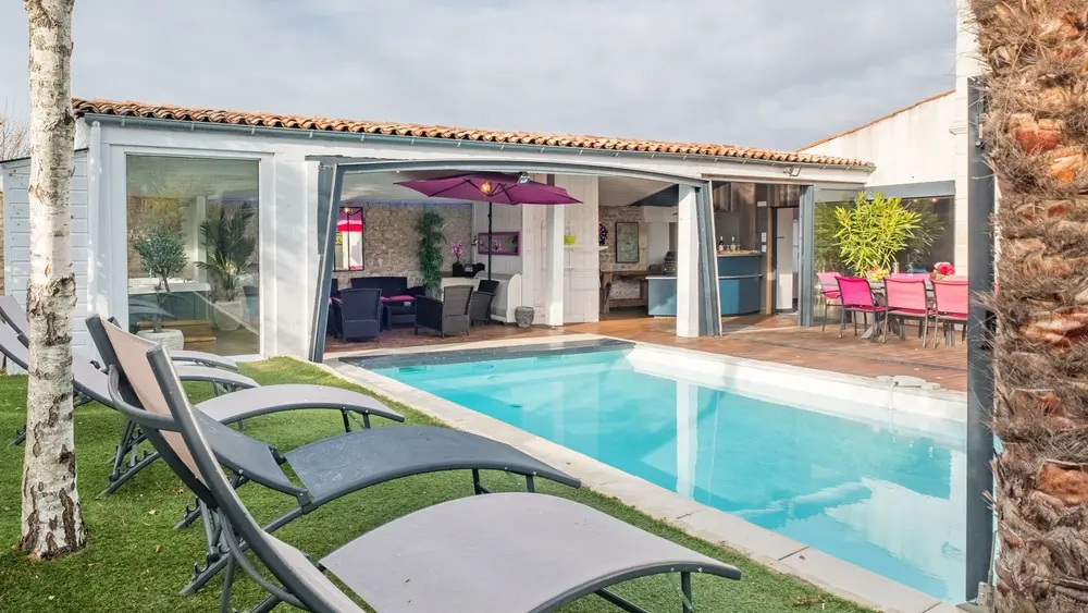 Piscine extérieure avec bains de soleil.