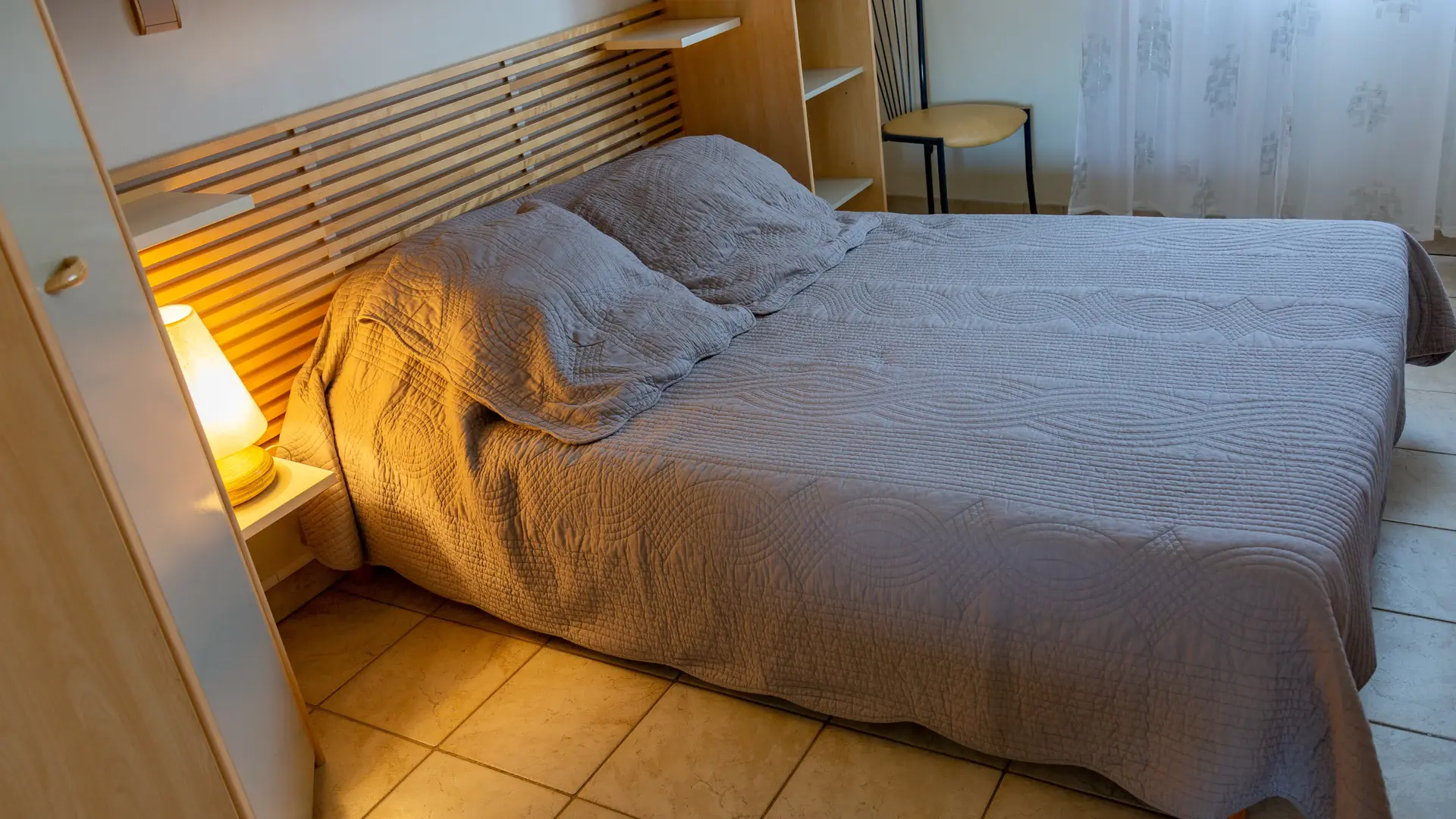 Une chambre aux tons doux et à la décoration soignée, équipée de rangements pratiques et d’un couchage confortable.