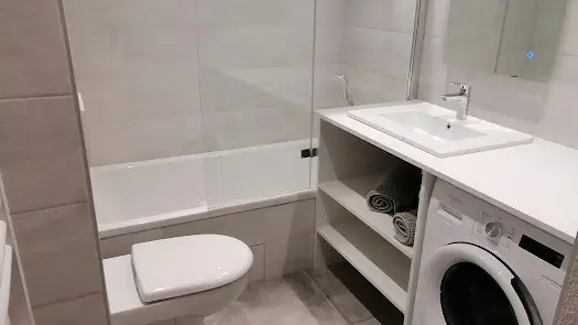 Salle de bain avec bagnoire, wc et machine à laver