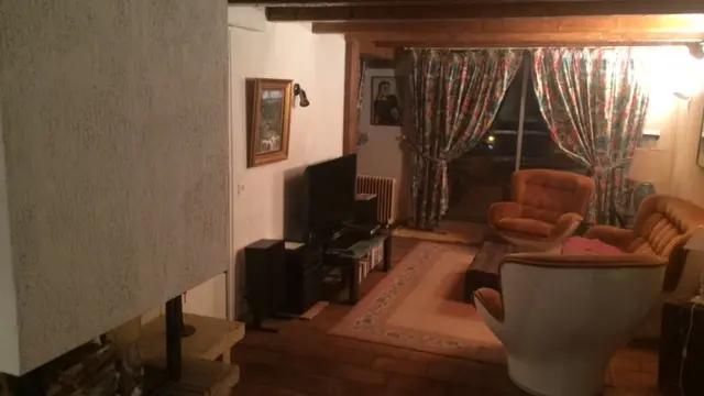 Séjour avec canapé, fauteuils, TV, tapis, fenêtre