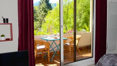 Le studio se compose d'une pièce principale avec un espace repas donnant sur une terrasse extérieure accessible par une porte-fenêtre coulissante.