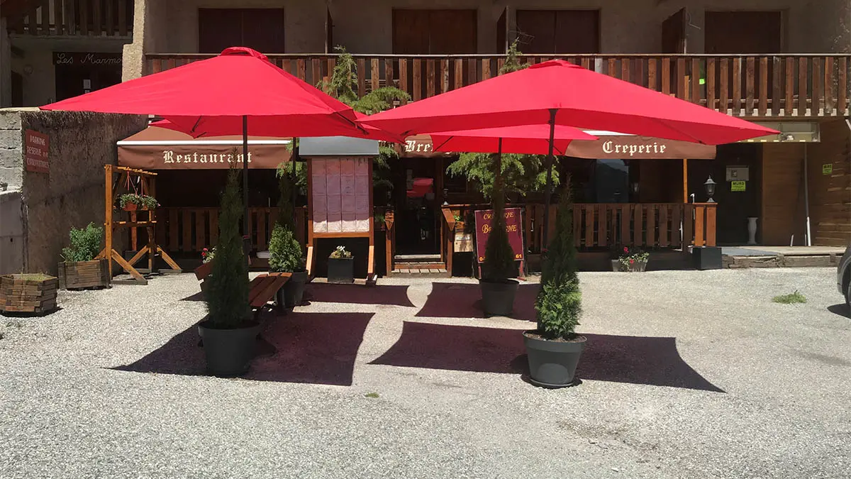 View from the crêperie terrace in summer, terrace with parasols and benches