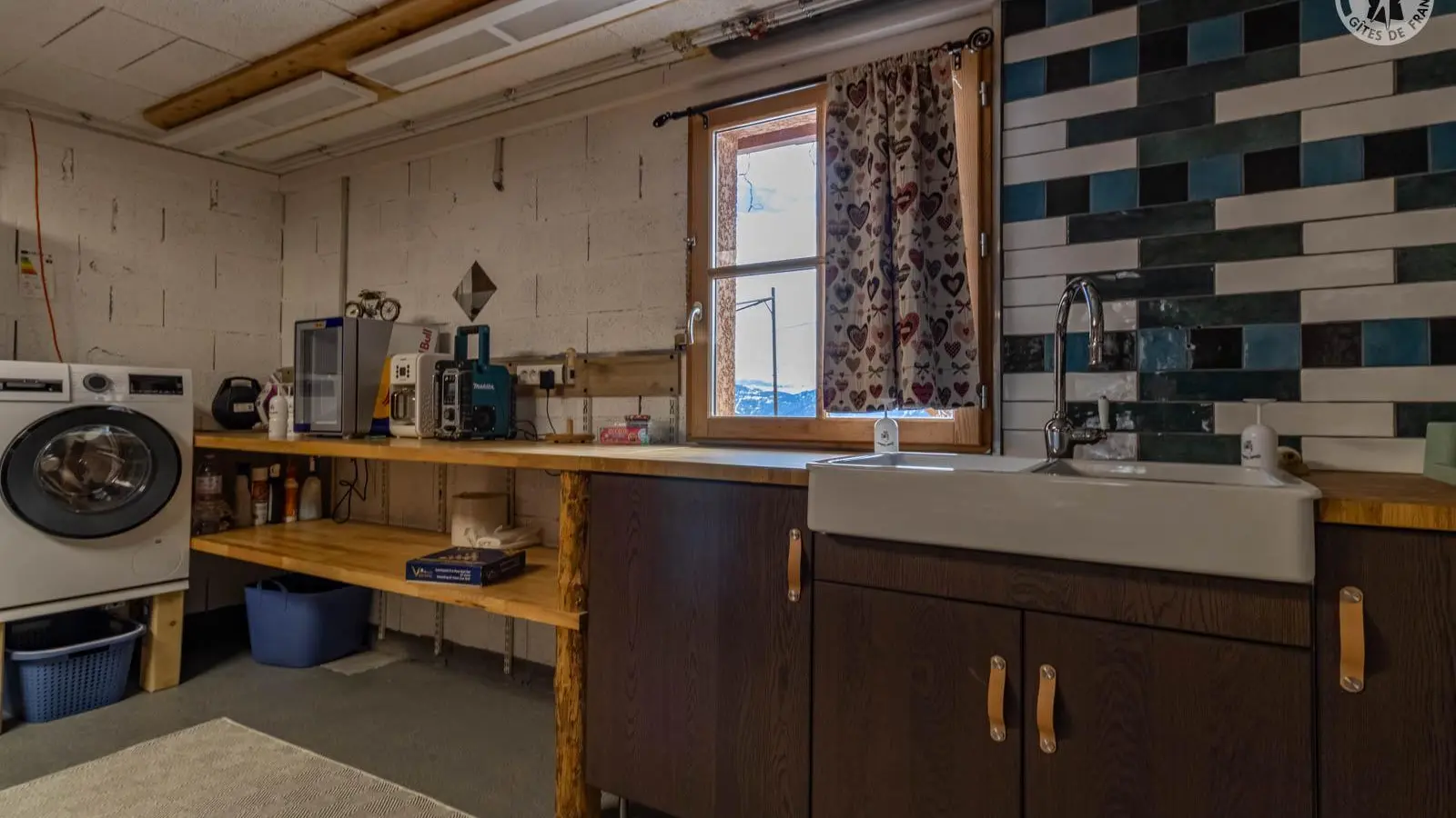 plan travail au sous sol avec lavabo, machine a laver le linge et séchoirs