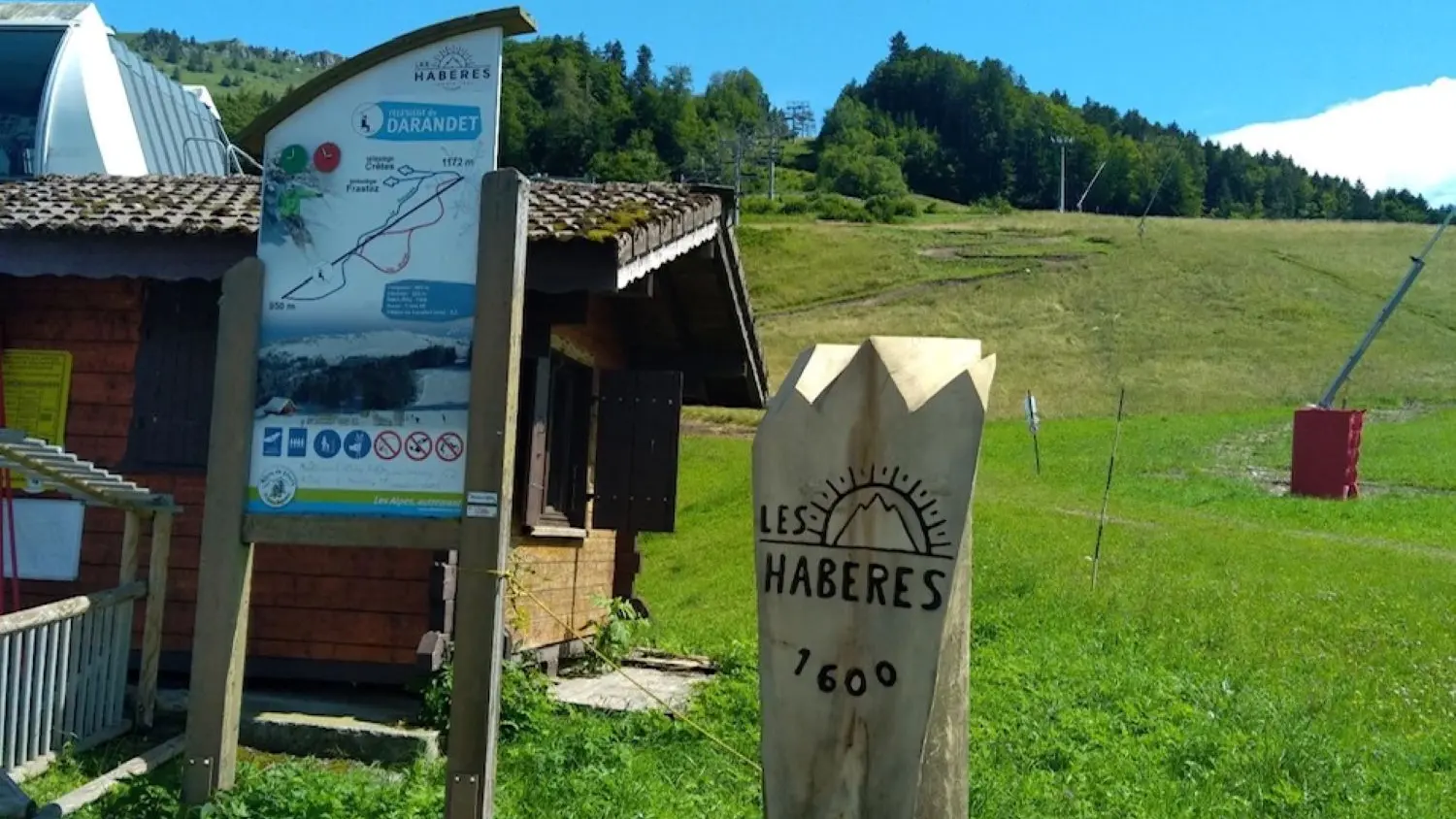 Totem bois pyrogravé Darandel, piste bleue et crêtes d'Hirmentaz-Habère Poche en arrière plan.