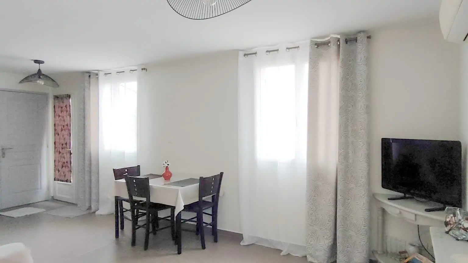 Grande pièce de vie lumineuse avec coin repas et salon convivial.