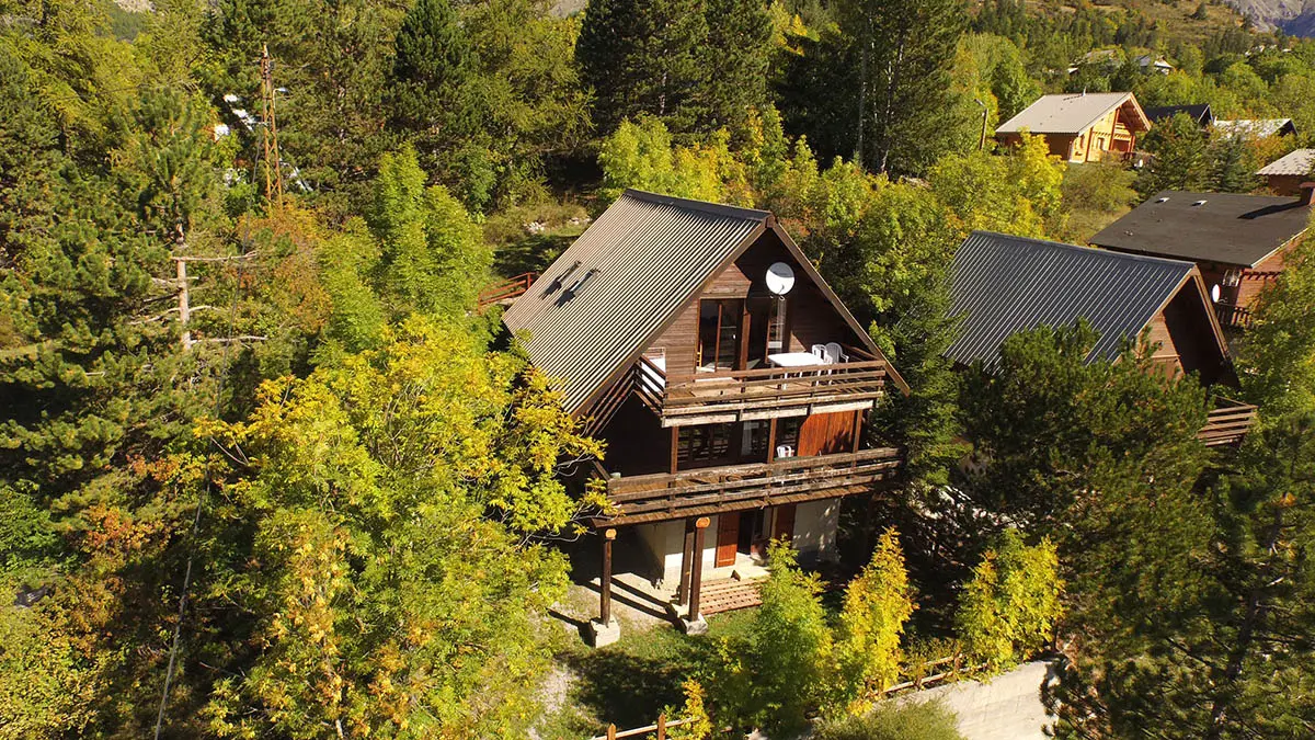 Vue du chalet à trois étages, balcons en bois, jardin, végétation