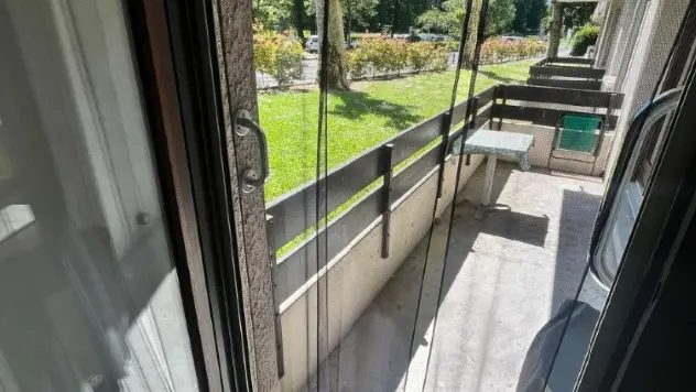 L'accès au grand balcon s'effectue par une porte fenêtre fermée par une moustiquaire. Le balcon donne sur le Parc d'Uriage.