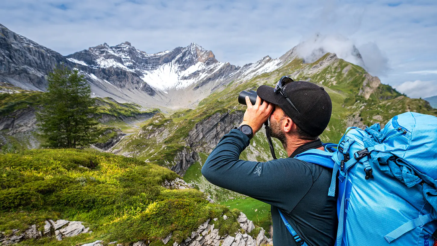Une personnes qui regarde le paysage avec des jumelles