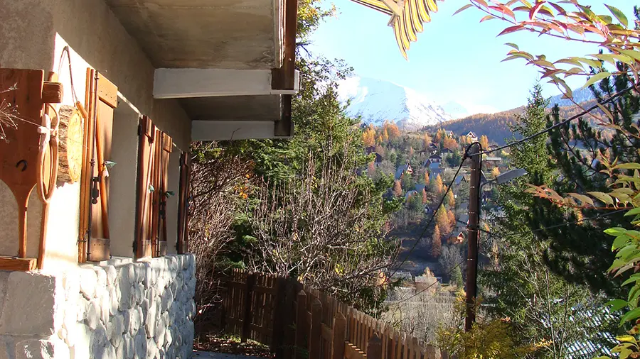 Terrasse d'extérieur d'une maison en pierre, palissade en bois, table d'extérieur, paysage automnal