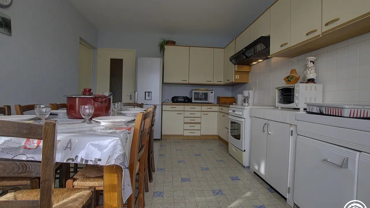 La cuisine avec sa grande table à manger