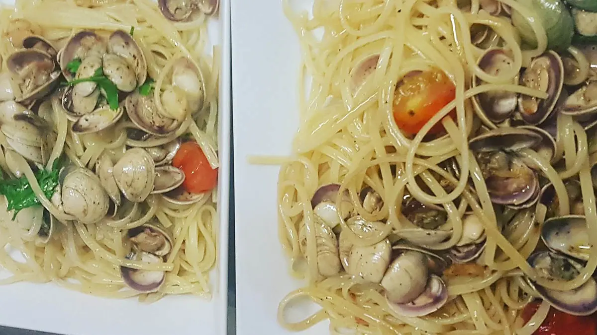 Plats de linguine avec crustacés, tomates cerise et basilic