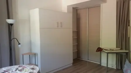 Cette pièce de vie est équipée d'un coin salon avec un canapé-lit, d'une table et d'un espace de rangement.