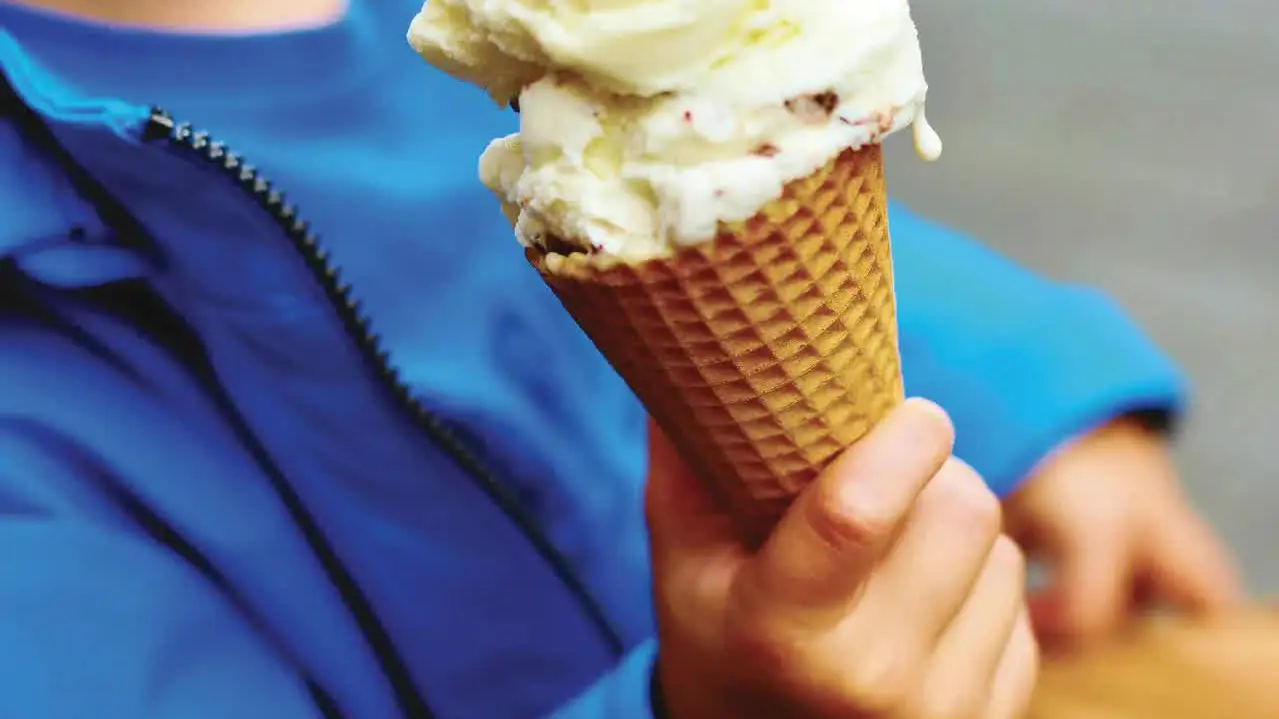 Un enfant déguste une glace artisanale en cornet.