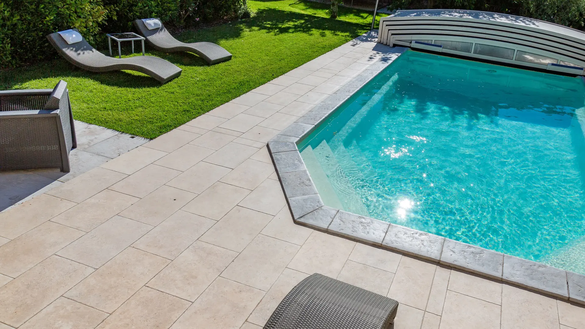 Une piscine bordée de dalles claires, avec accès sécurisé et espaces détente, idéale pour se rafraîchir durant les belles journées d’été.