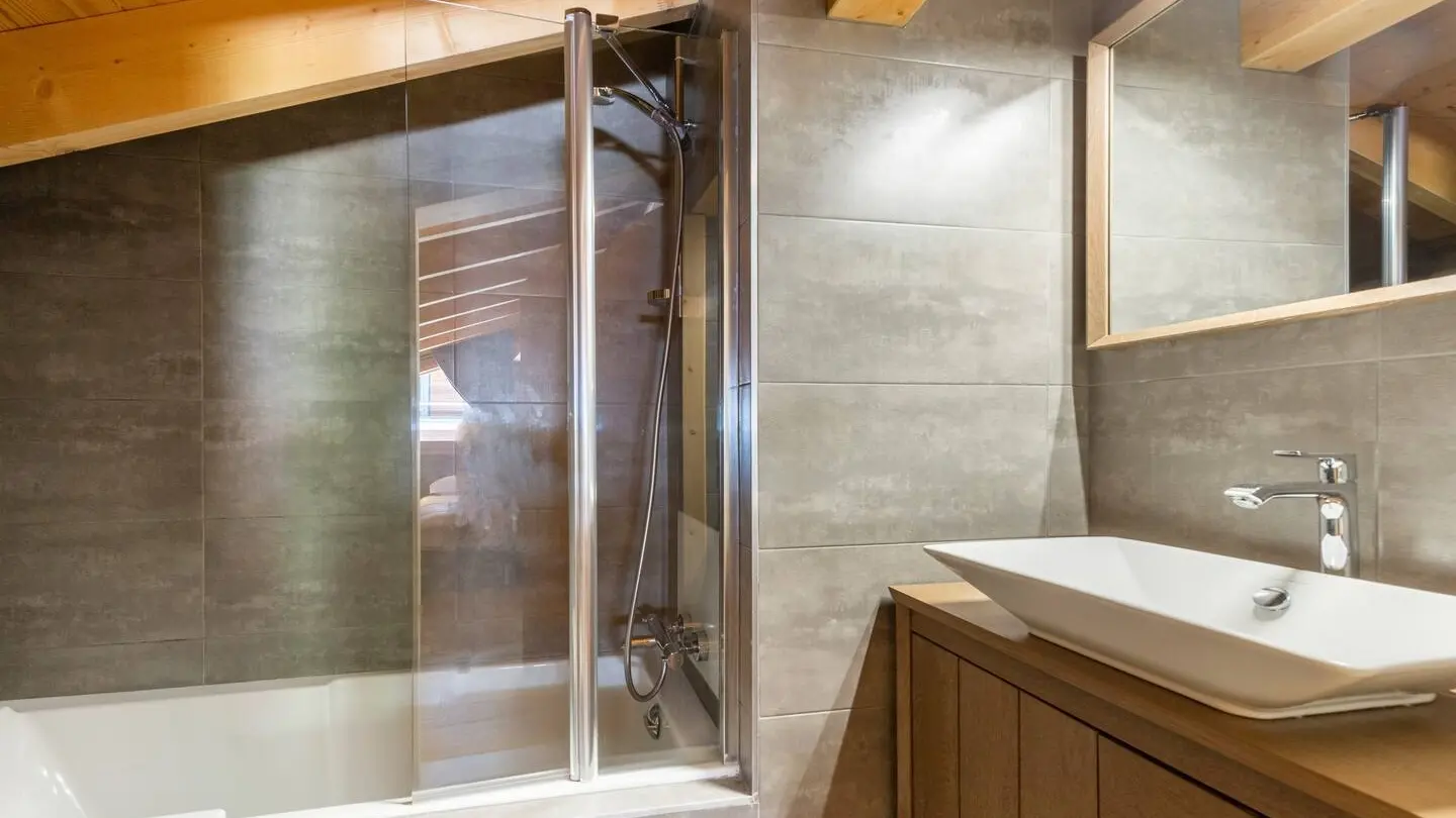 Salle de bains avec baignoire, vasque et son meuble, grand miroir