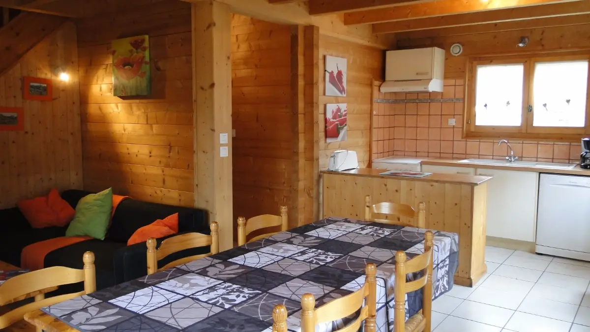 Location d'un chalet entre lac et montagne à Bernex - espace repas avec cuisine au fond