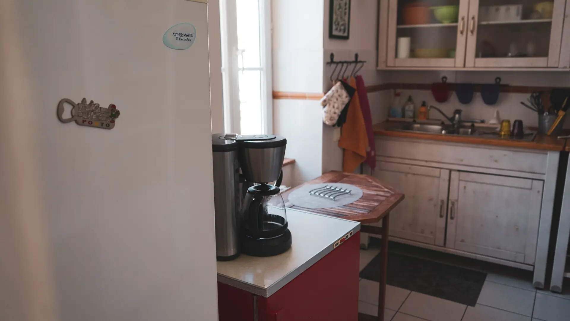 La cuisine équipée avec son grand réfrigérateur et son congélateur indépendant avec sa porte rouge dynamique des Fillattes