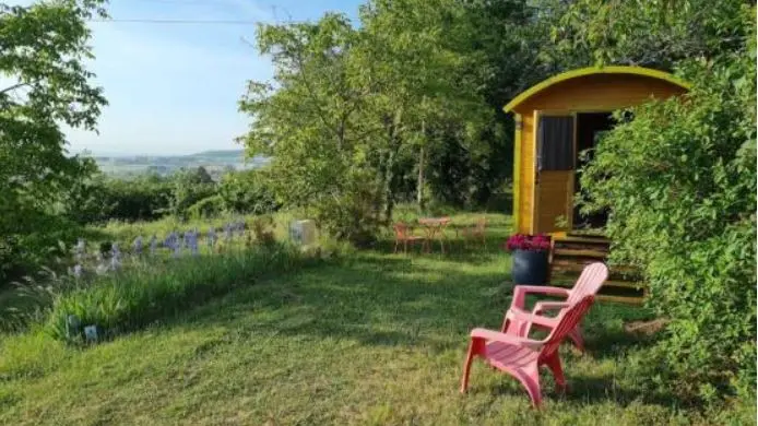 Vue sur l'aire naturelle de camping et la campagne environnante.