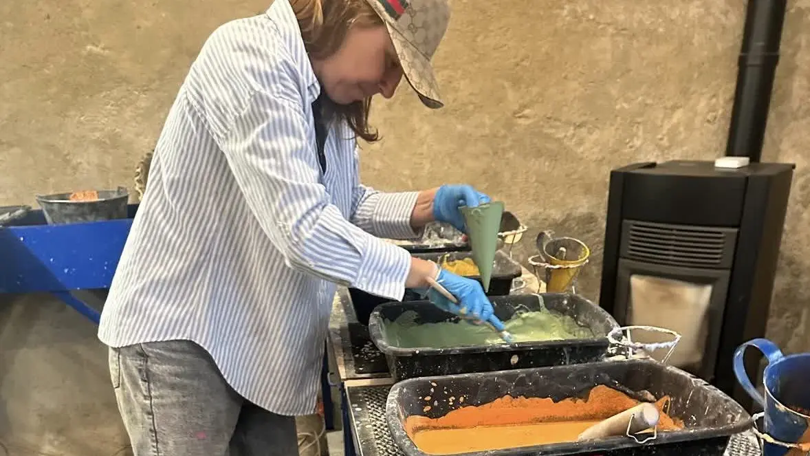 Artisan en plein mélange des pigments colorés avant le coulage dans les moules.