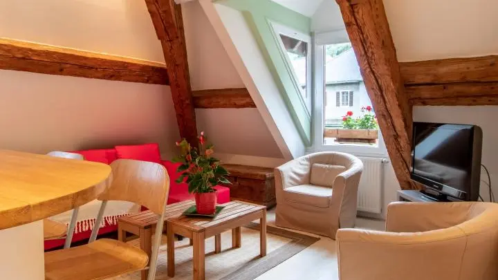 Pièce de vie mansardée aux poutres apparentes